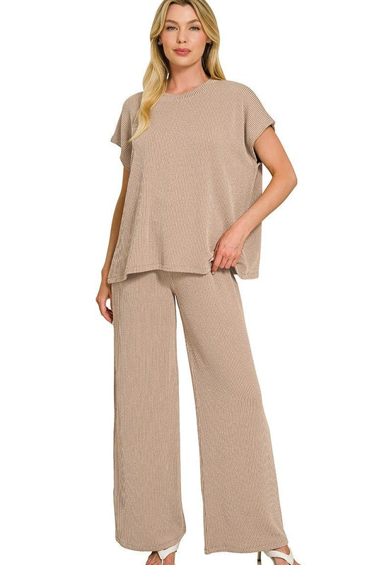 Woman wearing a beige outfit with wide-leg pants on a white background